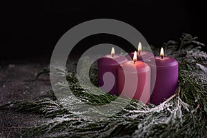 Christmas wreath with four burning purple advent candles