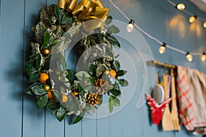 Christmas wreath hanging on blue annoyance wall with lights on it, decor apartment or kitchen