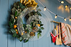 Christmas wreath hanging on blue annoyance wall with lights on it, decor apartment or kitchen photo