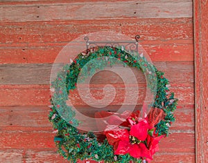Christmas wreath hanging on a rustic red door photo