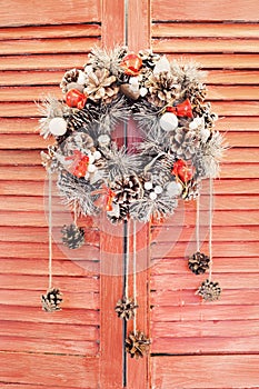 Christmas wreath hanging on wooden blinds photo