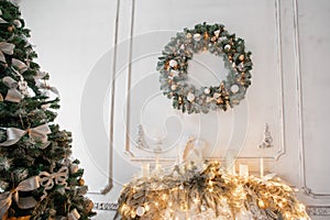 Christmas wreath of holly with white bows over the fireplace, a cozy winter morning