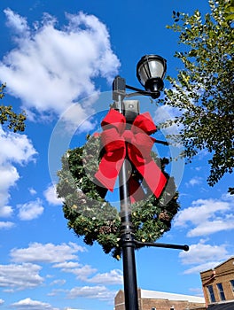 Christmas wreath on light pole bright blue sky