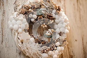 Christmas wreath with little white cotton balls, cones and toy birds