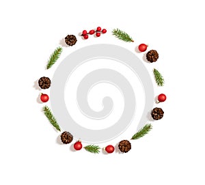 Christmas wreath made of cones, fir branches and red ornaments isolated on white background. New Year frame. Minimalism. Copy