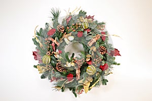 christmas wreath with pine cones and red berries on white background photo