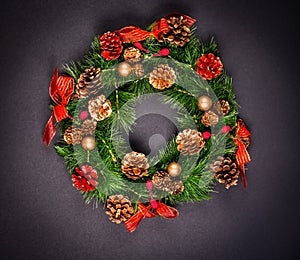 Christmas wreath with pinecones on black background