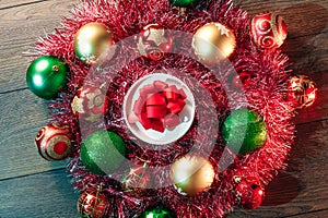 Christmas wreath of red garlands and Christmas toys on the background of a wooden table. Merry Christmas and happy holidays. View