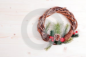 Christmas wreath of twigs with pine needles and cones on light b