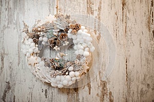 Christmas wreath with white cotton balls, cones and toy birds