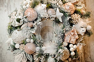 Christmas wreath with white and rosa color toys, balls, tapes and flowers sprinkled with snow photo