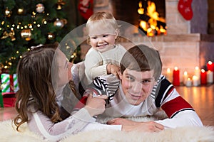 Christmas, x-mas, family, people, happiness concept - happy parents playing with pretty baby photo