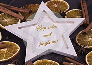 Christmas Xmas New Year Holiday card with wooden star cinnamone star anice dried oranges and text Keep calm and jingle on photo