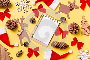 Christmas yellow background with holiday toys and decorations. Top view of notebook. Happy New Year concept