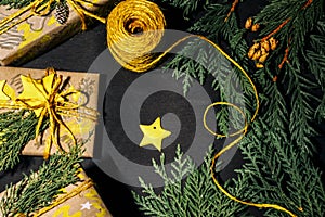 Christmas yellow handmade gift boxes on black background top view. Merry Christmas frame. Winter xmas holiday theme. Happy New