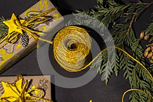 Christmas yellow handmade gift boxes on black background top view. Merry Christmas frame. Winter xmas holiday theme. Happy New