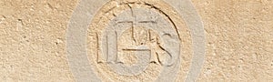 Christogram IHS  monogram symbolizing Jesus Christ on stone wall photo