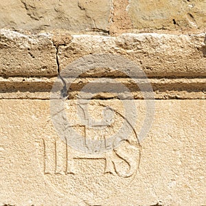 Christogram IHS  monogram symbolizing Jesus Christ on stone wall photo