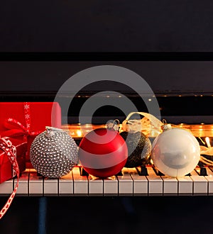 Chritmas balls and gifts on piano keyboard. Xmas music, songs