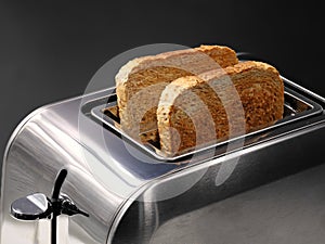 chrom toaster with wholemeal bread slices isolated on black background photo