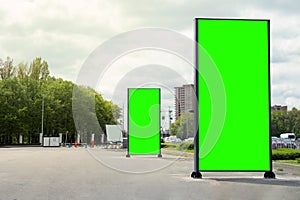 Chroma key compositing. Empty billboards with green screen on city street. Mockup for design