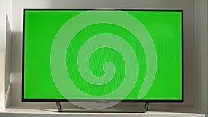 Chroma key smart TV in living room closeup. Device with blank screen in sunlight