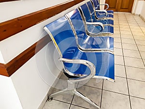 Chrome and blue empty plastic seats on hospital corridor