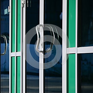 Chrome door handle and glass of modern aluminium office facade