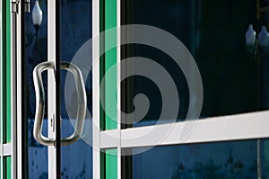 Chrome door handle and glass of modern aluminium office facade