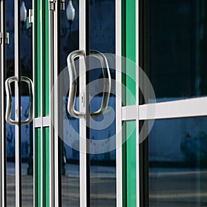 Chrome door handle and glass of modern aluminium office facade