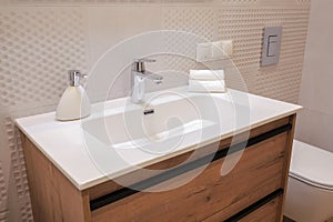 Chrome faucet with white ceramic sink in the bathroom