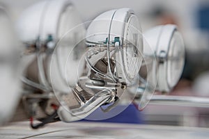 Chrome headlamps with reflection visible,