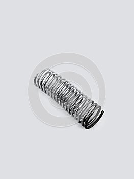 Chrome metal spring over white background