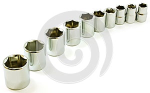 Chrome ratchet sockets in a curve, on white