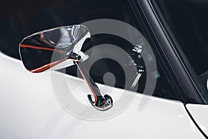 Chrome rear mirror on white car with classic design