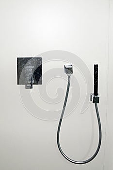 Chrome shower faucet with water drops on white background