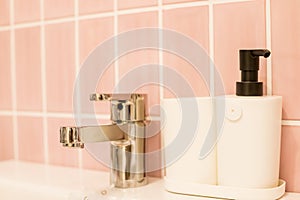 Chrome water faucet with marble counter tops,white sink.Luxury faucet mixer in bathroom. bathtub and water tap. soap in
