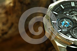 Chronograph watch put beside wood background.