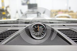 Chronometer with a clock in a luxury sports car. To measure lap times in races. Chronograph in top panel of premium car. Pitstop photo