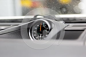 Chronometer with a clock in a luxury sports car. To measure lap times in races. Chronograph in top panel of premium car