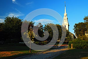 A chruch steeple rises over a public park