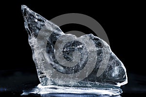 Chrystal clear frosty textured natural ice block in cold light blue tones, isolated on black background