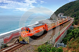 A Chu-Kuang Express hauled by a diesel-electric locomotive coming out of a tunnel & arriving at Duoliang Station