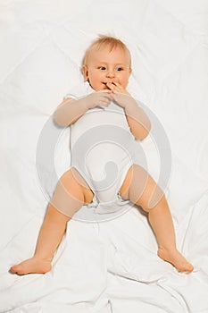 Chubby small baby with fingers near his mouth photo