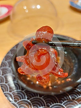 Chuka iidako (Seasoned baby octopus) grabbed with stainless chopstick