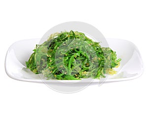 Chuka salad. Seaweed with sesame seeds in ceramic plate isolated on white. Japanese Cuisine