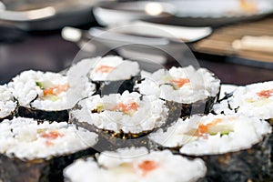 Chumaki Sushi Rolls with Tuna, Salmon, Rice, Cucumber, Avocado And Nori Seaweed on a Plate with Soy Sauce Dipping Dish and