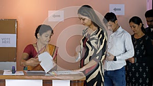 A Chunaav Adhikari checking the voting slips and the identity proof of the voters - Indian assembly elections, state elections