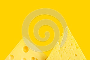 Chunk and wedge of Alpine creamy Tilsit Maasdam cheese on yellow background. Local delicacy produce healthy versatile diet