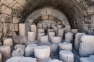 Chunks of antique Greek columns stored in basalt cavern, Rhodes, Greece